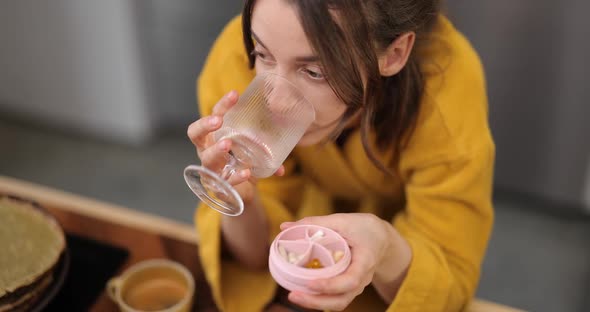 Woman Takes Pills in the Morning