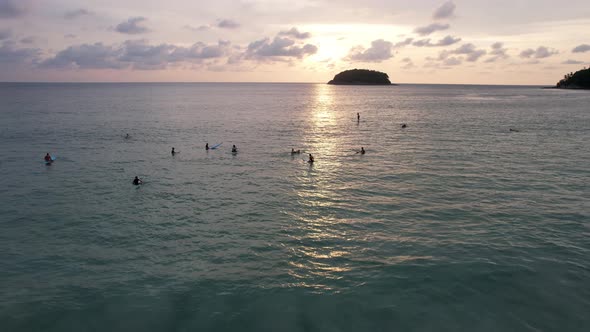 Surfers Catch Waves at Sunset