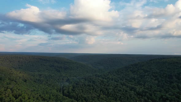 An aerial view of green hills with cloudy sky in the Allegheny National Forest