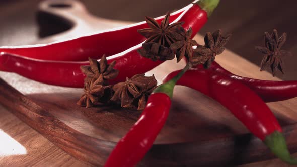 Red Chilli Pepper and Anise Falling Down on Wood