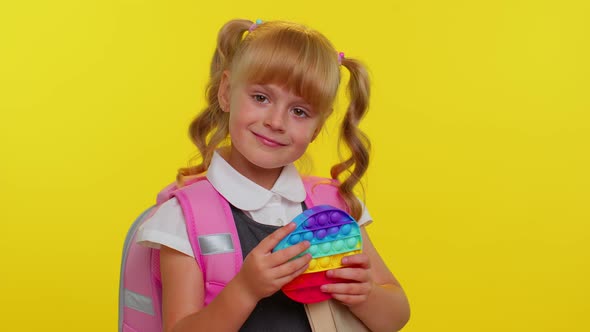 Joyful Pupil Girl Playing with Pop It Sensory Antistress Toy Kid Presses on Squishy Bubbles Game