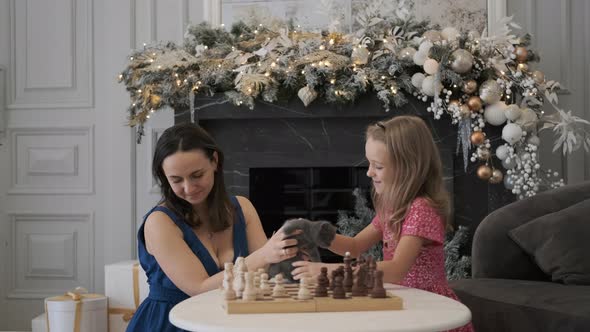 Woman with Daughter Play with Kitten in Christmas