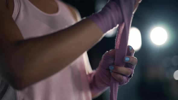 Close Up of a Athletic Woman is Wrapping Her Hands with Bandages in the Gym
