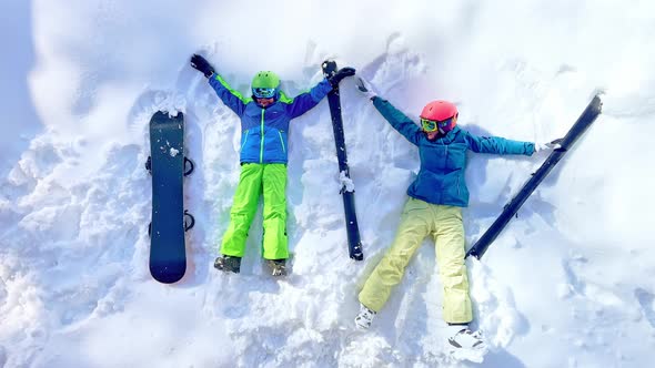 Woman and Young Boy with Snowboard in Ski Outfit View From Above