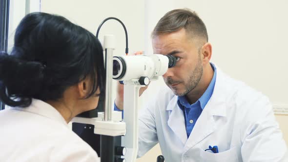 Attentive Ophthalmologist Examines the Eyes of His Patient