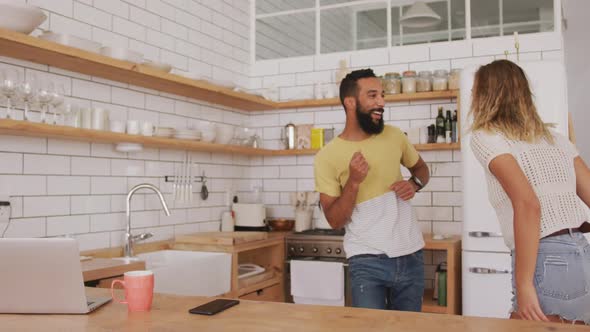 Happy couple dancing together in the kitchen