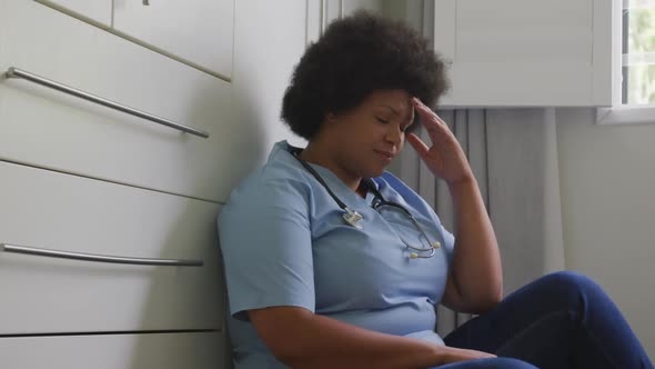 Video of tired plus size african american female doctor resting at social room