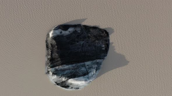 Top Down View Of Floating Iceberg In Solheimajokull Glacier, Iceland - aerial drone shot