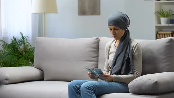 Sad Young Woman With Cancer Counting Money, Insurance, Expensive Treatment