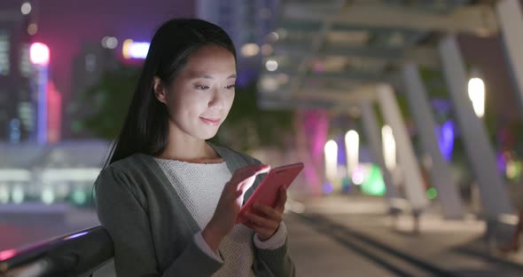 Woman checking on cellphone at night