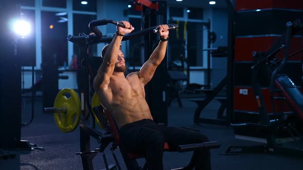 Training with equipment in gym. Fitness man doing exercises at gym