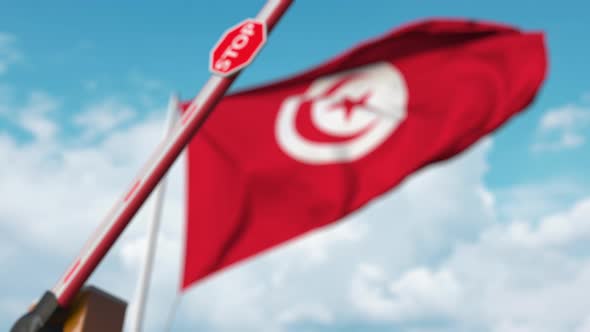 Closing Boom Barrier with Stop Sign Against Flag of Tunisia