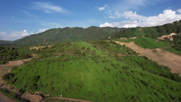 Green Hills and Mountains with White Clouds