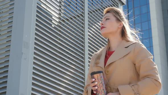 Blond Holds Thermos