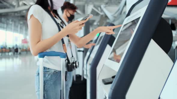 Asian male and female wearing protective face mask in airport terminal