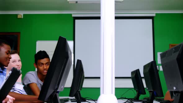 Students studying on computer in classroom