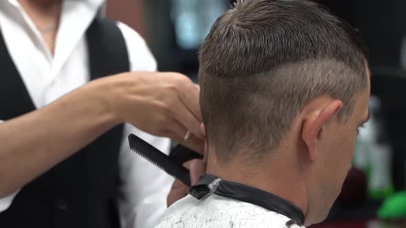 Barber Cuts the Hair in the Barbershop. Close-up