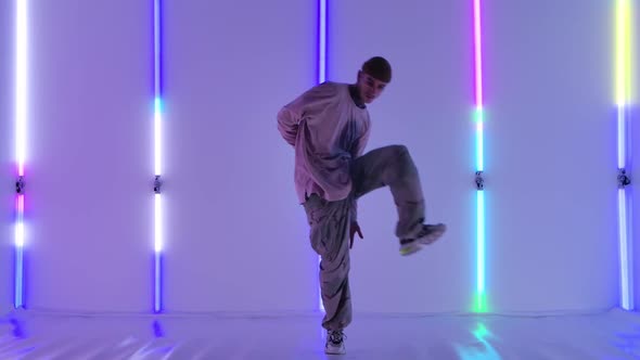 Cool Young Talented Hip Hop Guy Is Dancing Against the Backdrop of Bright Neon Lights Performing