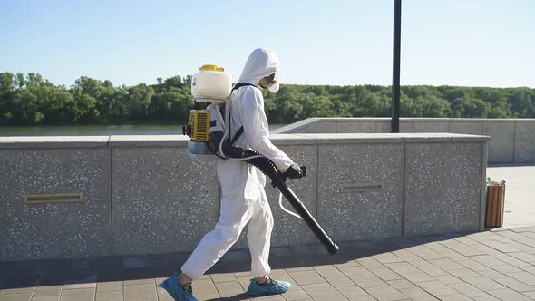 Young Sanitation Worker in Hazmat with Pressure Washer Outdoors