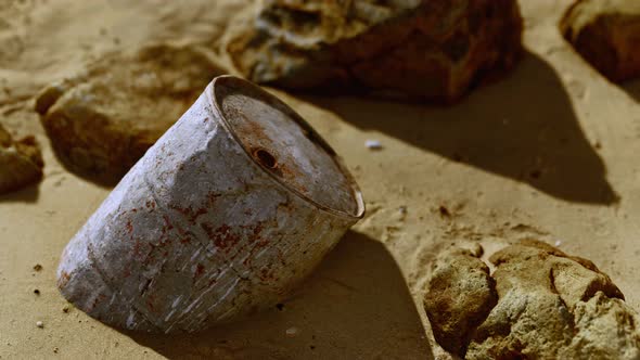 Rusty Metal Oil Barrel on Sand Beach