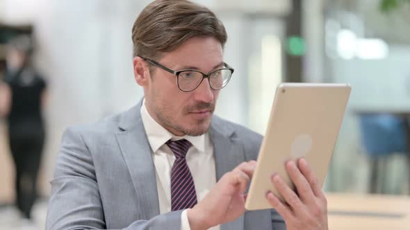 Portrait of Excited Businessman Celebrating Success on Tablet