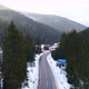 Flying over the road in winter, surrounded by green forest - VideoHive Item for Sale