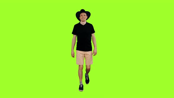 Friendly Guy in Black T-shirt and Cowboy Hat Walks on Green Background