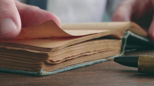 Closeup of a Hand Turning the Pages of an Old Book