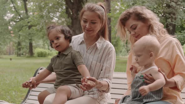 Moms with Toddler Kids Resting in Park