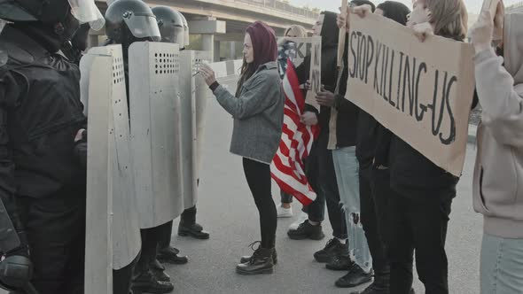 Woman Putting Flowers into Riot Police Shields at Protest