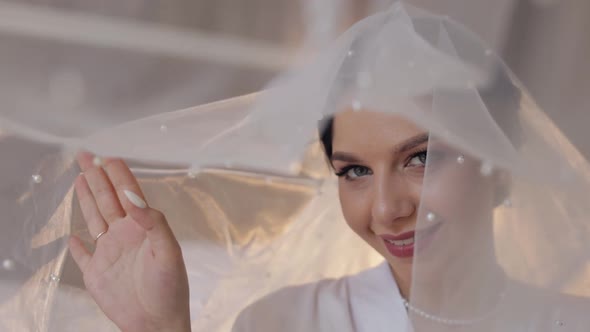 Bride in Boudoir Dress Under Veil and in a Silk Robe Wedding Morning Preparations Before Ceremony