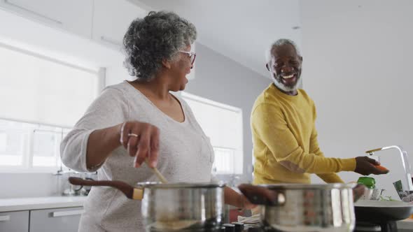 A senior african american couple spending time together at home and cooking social distancing in qua