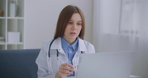 Female Head Physician of Hospital Is Communicating with Doctors By Online Video Conference at Laptop