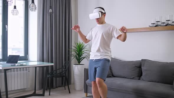 Man in Futuristic Virtual Reality Glasses Does Sports and Plays with a Virtual Soccer Ball Sports
