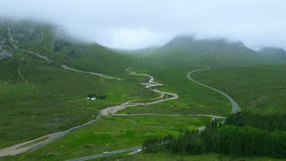 Panning up drone shot reveals remote road in Scottish mountains