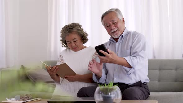 Couple Asian elderly video conferent online with smart phone in living room.