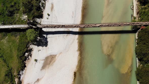 Aerial Top Down View of Sheep and Rams Crossing the Mountainous River on the Bridge with Shepherd in