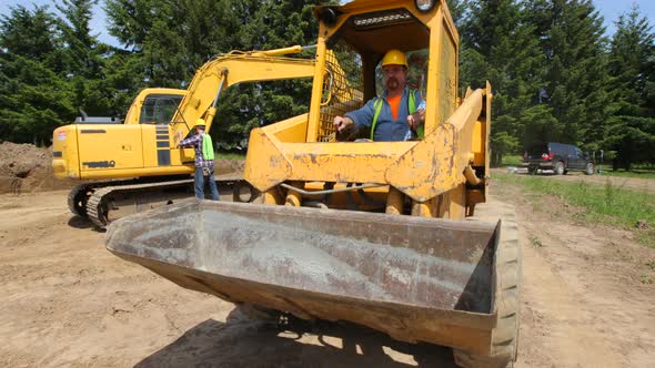 Construction worker driving excavation equipment alt