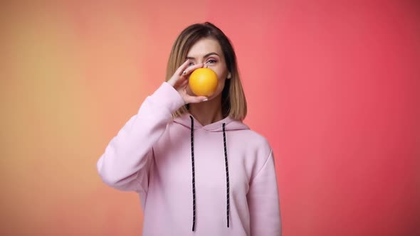 Smiling Blonde Caucasian Woman Holding Oranges in Her Hand