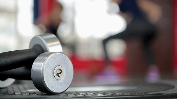 Defocused silhouette of sportive lady doing fitness exercises, gym background