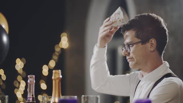 Close Up Portrait of Unhappy and Lonely Caucasian Guy Sitting at Table During Birthday Party