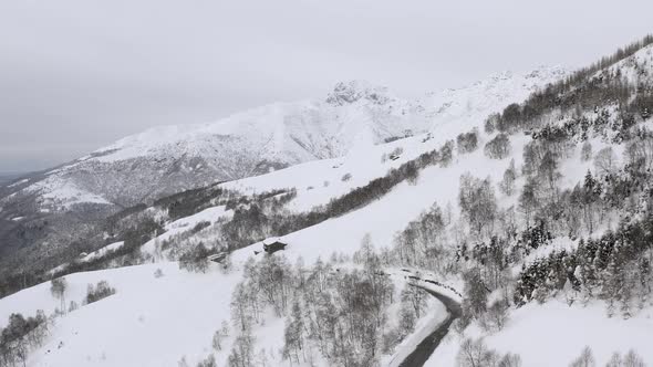 Aerial View of Snow Capped Mountain Range Landscape in Winter During Sunset