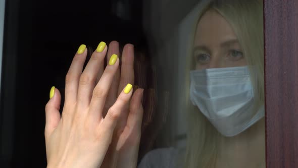 Two girls, sisters touch their hands with their palms through a glass window,