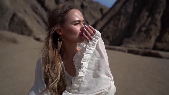 Romantic Pretty Woman in White Dress Is Standing in Sandy Desert Alone, Medium Portrait