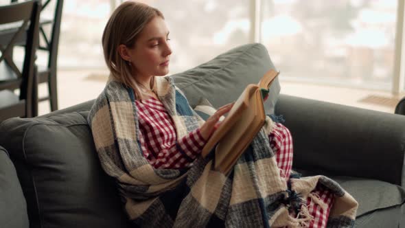 Pensive blonde woman reading book