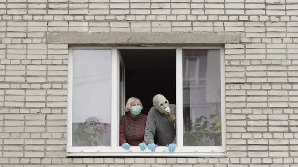 Old Grandparents Stay at Window Isolated at Home on Quarantine. Coronavirus