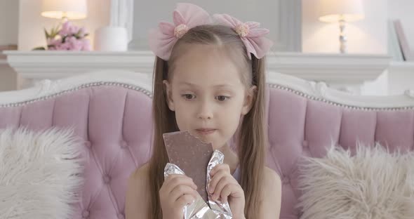 Portrait of Charming Little Girl Eating Chocolate, Brunette Caucasian Kid Biting Sweet Dessert 