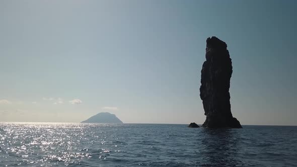 Aerial View on High Rock in Mediterranean Sea Against Horizon and Lipari Island. Blue Sky, Sunset