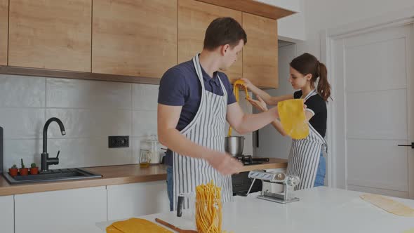 Young Couple Making Home Made Pasta at Kitchen