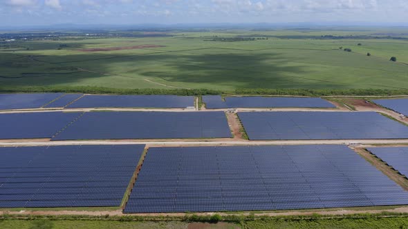 Photovoltaic Panels Park On Green Field At Daytime - aerial drone shot